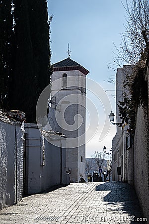 Albaicin street with the tower of the church of San Nicolas in the background Stock Photo