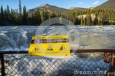 Warning sign not to climb the fence at Athabasca Falls in Jasper National Park Editorial Stock Photo