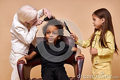 Albino child girl combing curly hair of africanamerican boy isolated Stock Photo