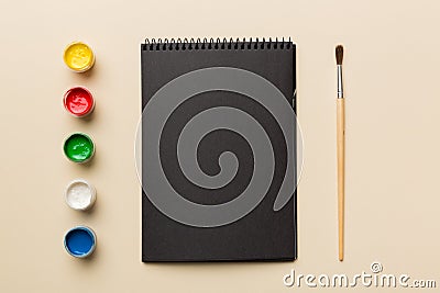 Album pages and paints, pencils, brush on a colored background. Top view with empty space. workplace for creativity. home teaching Stock Photo