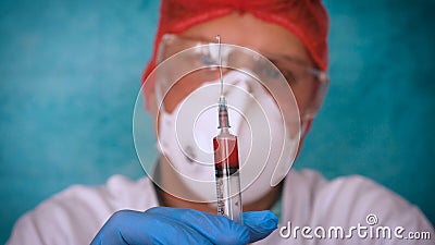 The alchemist checks the test tubes with a test of different compositions, in a white coat, a respirator, goggles, rubber white gl Stock Photo