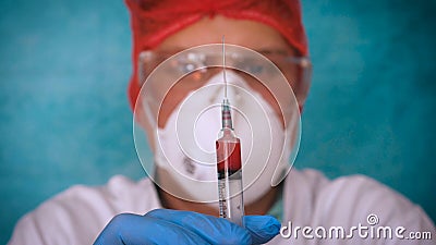 The alchemist checks the test tubes with a test of different compositions, in a white coat, a respirator, goggles, rubber white gl Stock Photo