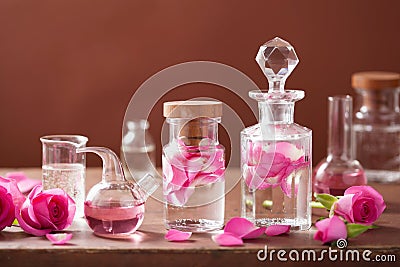 Alchemy, aromatherapy with rose flowers, flasks Stock Photo