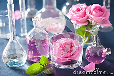 alchemy and aromatherapy set with rose flowers and chemical flasks Stock Photo