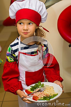 Alchevsk, Ukraine - July 30, 2017: School cooks for children. Learn to cook pasta with sausages Editorial Stock Photo