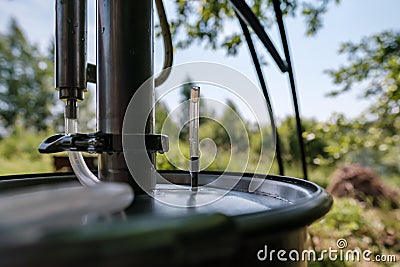 Alcohol mashine in a village courtyard, on a blurred background. Preparation of an intoxicating beverage. Close-up. Stock Photo