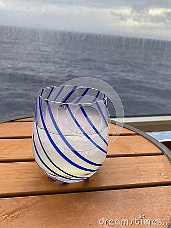 An alcoholic beverage of vodka and lemonade on a table aboard a cruise ship balcony overlooking the ocean Stock Photo