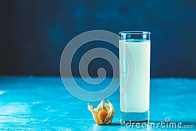 Alcoholic cocktail with Ouzo greek anise brandy or Arabic alcohol drink Raki in highball glass, decorated Physalis peruviana and Stock Photo