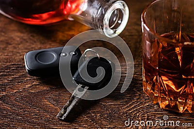 Alcoholic drink in a glass and car keys on a wooden desk. Drunk driving concept Stock Photo