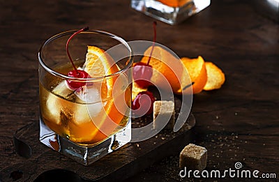 Alcoholic old fashioned cocktail with orange slice, cherry and orange peel garnish Stock Photo