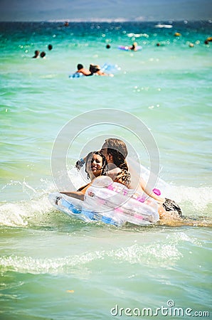 Alcudia, Spain 13.09.2011 - Couple swiming on inflatable mattress in shallow water at Playa de Muro. Mallorca island famous Editorial Stock Photo