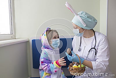 Easter in the hospital: the doctor nurse gives the girl a chocolate egg Stock Photo