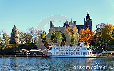 Alexandria Bay, New York, U.S.A - October 24, 2019 - The view of Boldt Castle and ferry surrounded by striking fall foliage along Editorial Stock Photo
