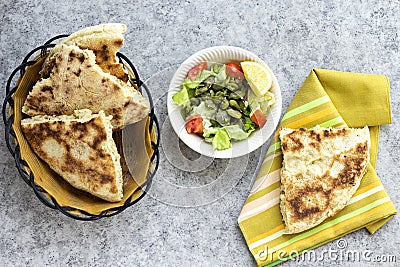 Algerian homemade bread named matlouh in arabic and salad bowl Stock Photo