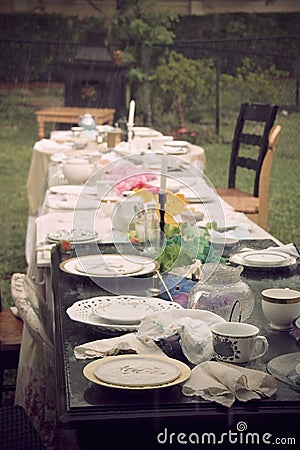 Alice in Wonderland Afternoon Tea Party Setting in Pouring Rain Stock Photo