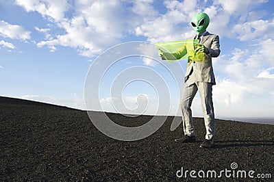 Alien Businessman Reading Map on Flexible Display Tablet Stock Photo