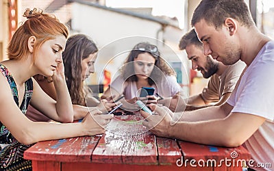 Alienation addiction. Friends sitting in cafe, typing on their phones Stock Photo