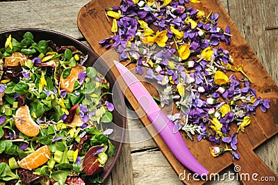 Alkaline, healthy food: salad with flowers, fruit and valerian salad Stock Photo