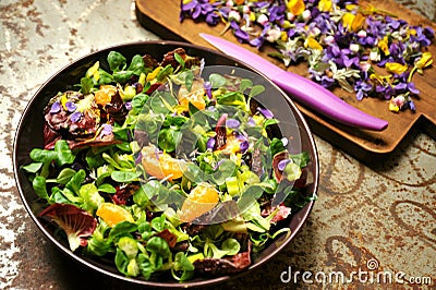 Alkaline, spring salad with flowers, fruit and valerian salad Stock Photo