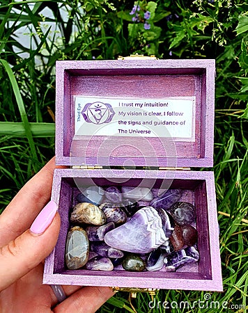 All Colour Colors CHAKRA purple THIRD EYE CHAKRA Gemstone Polished Hand Palmstones Rocks in wooden Box Near Water Spiritual Stock Photo