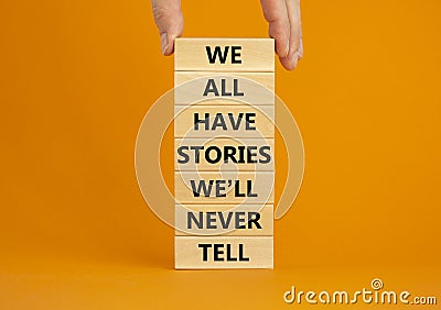 We all have stories we will never tell symbol. Blocks with words We all have stories we will never tell. Businessman hand. Stock Photo