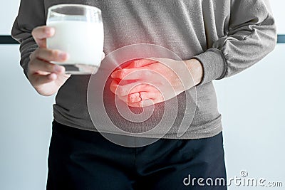 Allergy dairy intolerant,Lactose intolerance concept,Asian woman having a stomach pain with a glass of milk Stock Photo