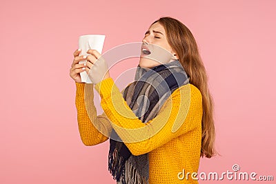 Allergy, flu sickness. Portrait of unhealthy red hair girl in big scarf, holding tissue and sneezing, blowing nose, suffering Stock Photo