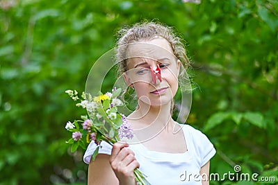 Allergy. Woman squeezed her nose with a clothespin, so as not to sneeze from the pollen of flowers Stock Photo