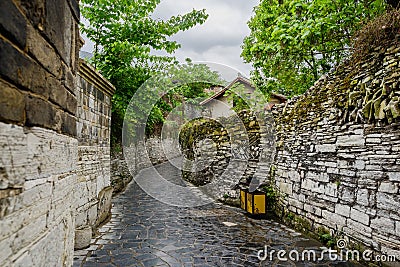 Alley with stone-stacked walls in ancient houses on cloudy day Stock Photo