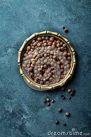 Allspice pepper, peppercorns on dark culinary background, top view Stock Photo