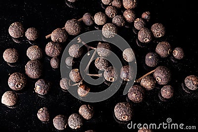 Allspice scattered on black Stock Photo