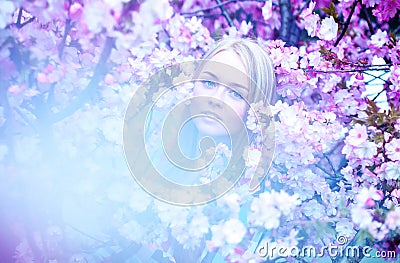 Alluring blonde woman in blooming flowers Stock Photo