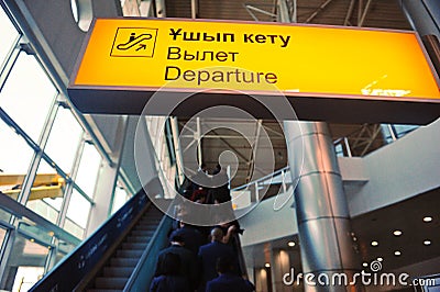 Almaty, Kazakhstan - 10.08.2015 : A bright sign with the inscription: departure on the background of the escalator at the airport Editorial Stock Photo