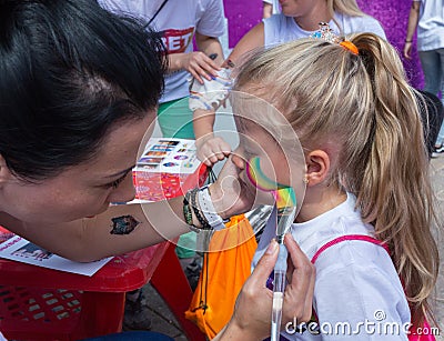 ALMATY, KAZAKHSTAN - JUNE 10, 2018: Unidentified girl makeup artist makes a bright carnival face painting to the Editorial Stock Photo