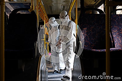 Almaty / Kazakhstan - 03.18.2020 : two men in a special suit disinfect the bus Editorial Stock Photo