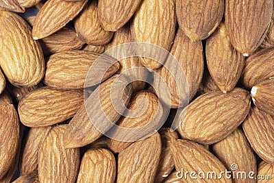 Almond background close up. Macro shot fresh almonds nuts background. Almond texture closeup. Almond heap texture background. Top Stock Photo