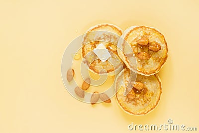 Almond flour pancakes with almonds syrup butter on yellow colored background Stock Photo