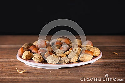 Almond and Hazelnut with shell in pink dish tablet wood Stock Photo