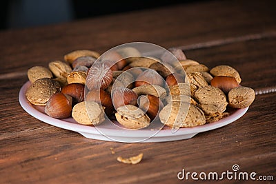 Almond and Hazelnut with shell in pink dish on a tablet wood Stock Photo