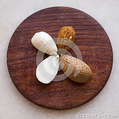 Almond kernel arranged in a flower pattern on a wooden plate Stock Photo