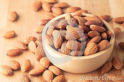 Almond seeds in a bowl wood on table wooden brown Stock Photo