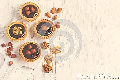 Almond walnut hazelnut chocolate small tarts on a white background, space for text, vintage toning Stock Photo