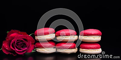 Red macaroon on black background with red roses Stock Photo