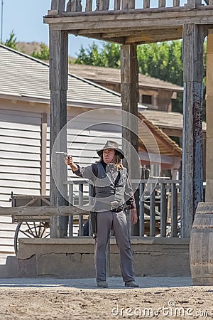 Live performance scenes, sheriff cowboy walking with shotgun on hands, on Oasys - Mini Hollywood, Spanish Western theme park, Alm Editorial Stock Photo