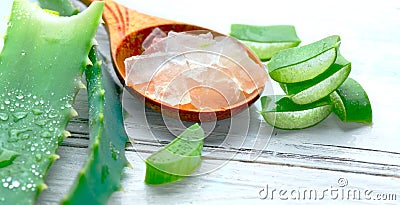 Aloe Vera gel closeup on white wooden background. Organic sliced aloevera leaf and gel, natural organic cosmetic ingredients Stock Photo