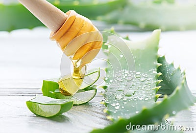 Aloe Vera with honey closeup on white wooden background. Sliced Aloevera natural organic renewal cosmetics, alternative medicine Stock Photo