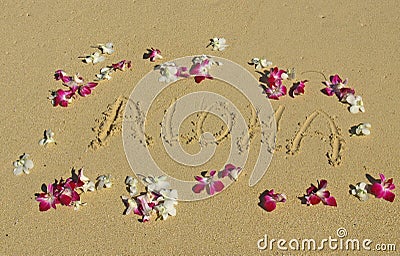 Aloha written in the sand with Orchids in Hawaii Stock Photo