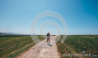 Alone backpacker traveler walks on contryside road in sultry aft Stock Photo