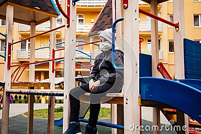 Alone boy with medical mask is sitting Stock Photo