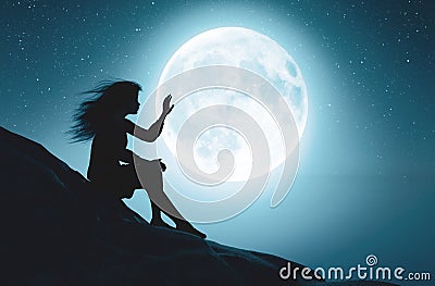 Alone girl touching the moon in starry night Stock Photo